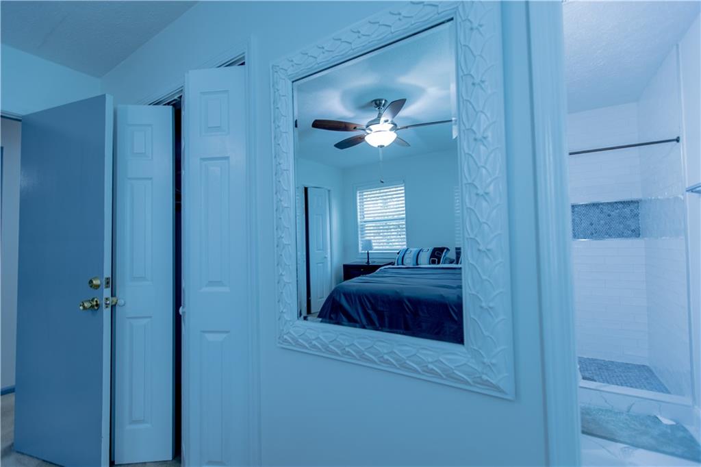 4735 North Springs Road Northwest Kennesaw, GA 30144 - Photo 23 of 34 a bedroom with a bed and a chandelier fan
