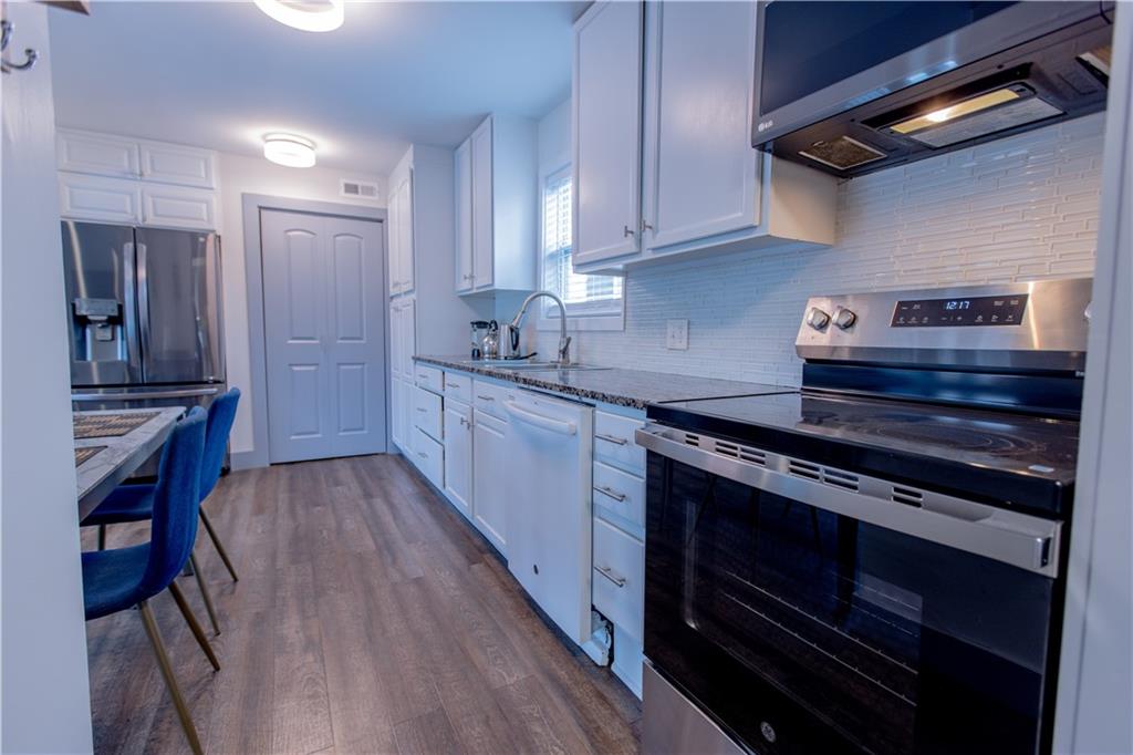 4735 North Springs Road Northwest Kennesaw, GA 30144 - Photo 28 of 34 a kitchen with stainless steel appliances granite countertop a stove and a refrigerator