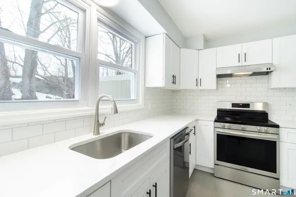 a kitchen with a sink stove top oven and cabinets