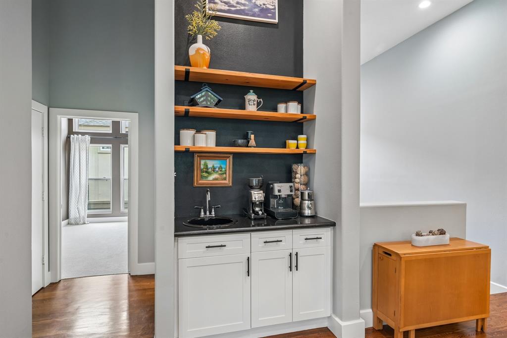 3553 Wheeler Street Dallas, TX 75209 - Photo 9 of 35 Built-in coffee bar with black granite countertop, floating wood shelves, and sink adjacent to private bedroom hallway