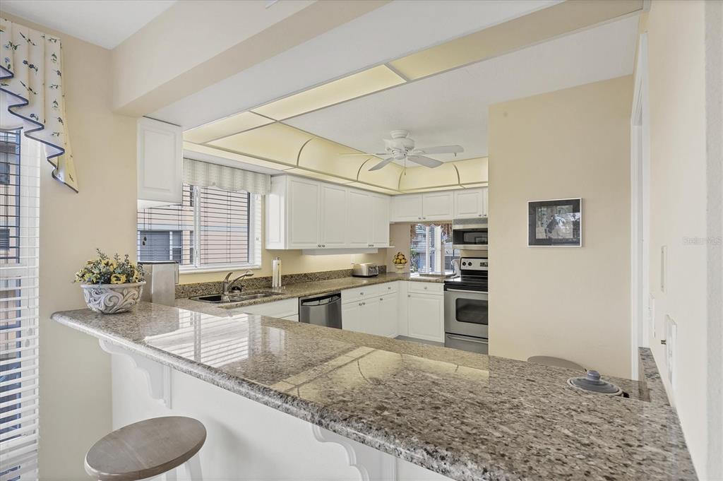 11000 Placida Road, Unit 1801 Placida, FL 33946 - Photo 11 of 53 a kitchen with stainless steel appliances granite countertop a sink stove and refrigerator