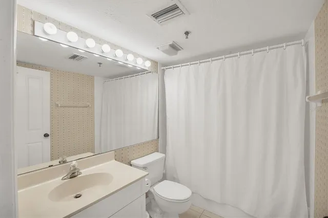 a bathroom with a toilet a sink and a mirror