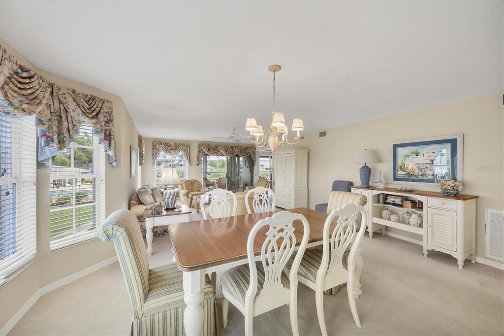 11000 Placida Road, Unit 1801 Placida, FL 33946 - Photo 9 of 53 a view of a dining room with furniture a chandelier and large windows