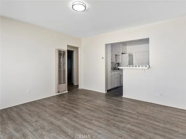 a view of a kitchen with wooden floor and a refrigerator