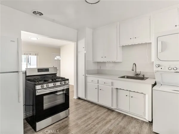 a kitchen with cabinets stainless steel appliances and wooden floor