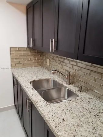 a kitchen with stainless steel appliances granite countertop a refrigerator and a stove