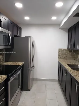 a bathroom with a granite countertop sink a toilet and bathtub