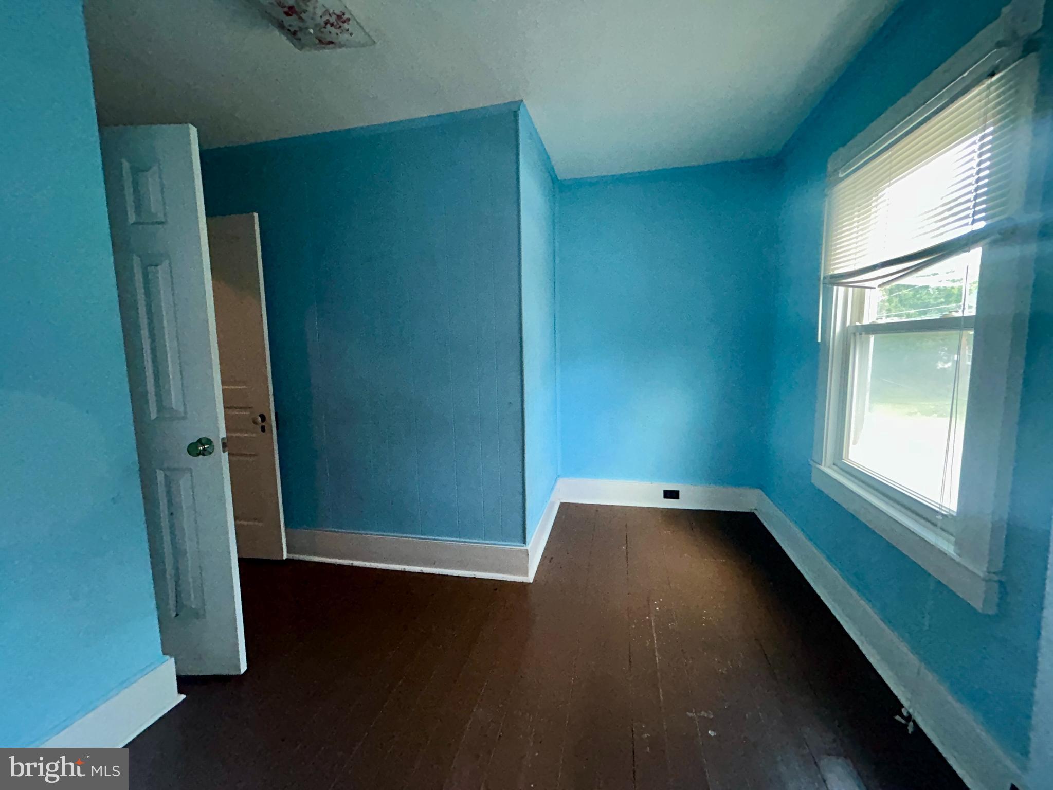 161 East Main Street Orange, VA 22960 - Photo 16 of 37 an empty room with wooden floor and windows with curtains