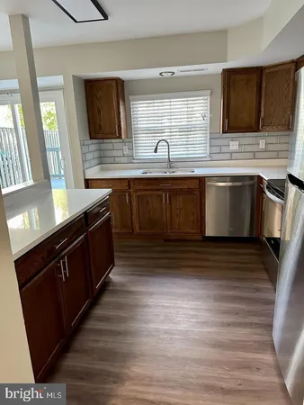 a kitchen with stainless steel appliances kitchen island granite countertop a stove a sink and a microwave