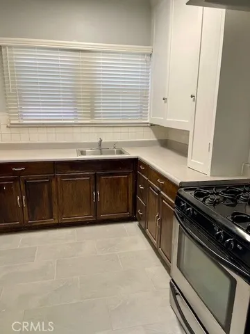 a view of a hallway with wooden floor and a bathroom