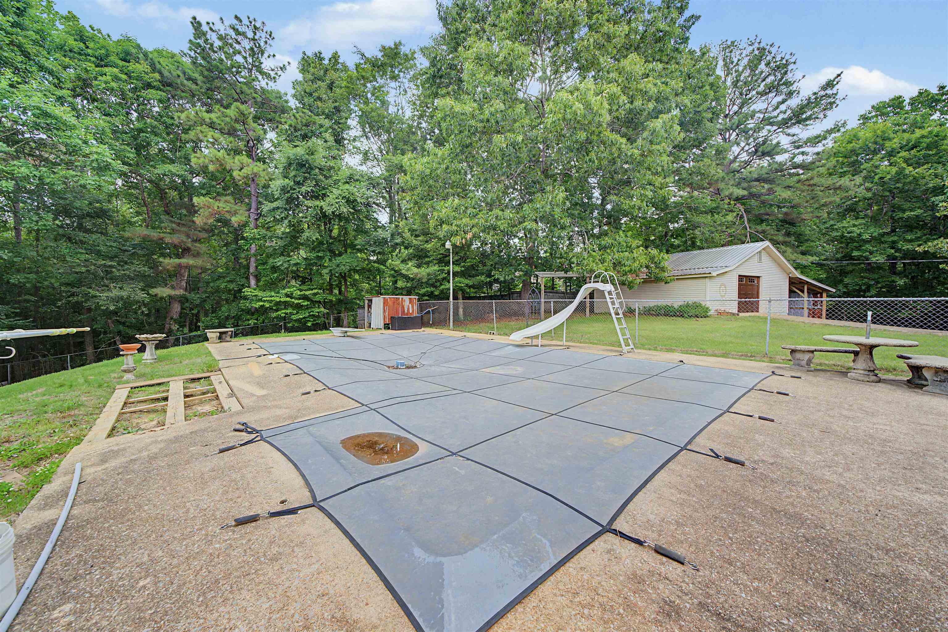 436 Skyline Road Selmer, TN 38375 - Photo 14 of 40 Outdoor swimming pool covered with a protective mesh, surrounded by concrete decking