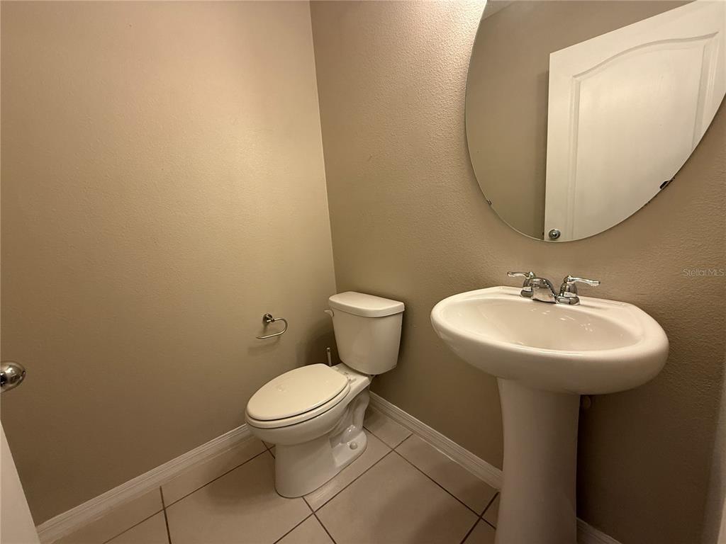1623 Reflection Cove St. Cloud, FL 34771 - Photo 11 of 33 a bathroom with a sink a toilet and a mirror