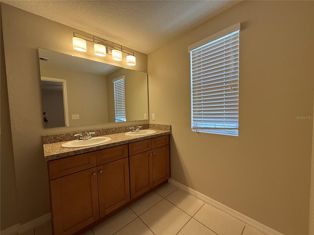 1623 Reflection Cove St. Cloud, FL 34771 - Photo 17 of 33 a bathroom with a sink and a mirror