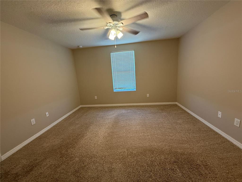 1623 Reflection Cove St. Cloud, FL 34771 - Photo 18 of 33 en empty room with windows and ceiling fan