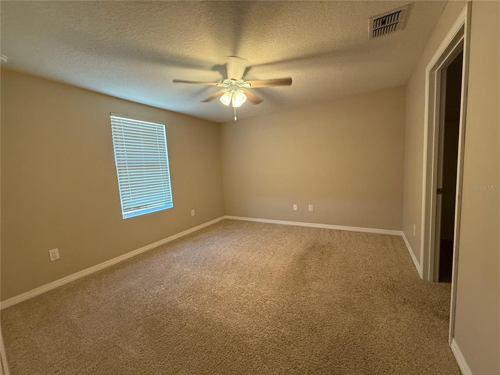 1623 Reflection Cove St. Cloud, FL 34771 - Photo 20 of 33 an empty room with a window and a fan