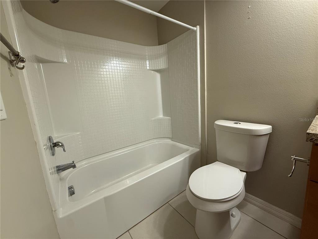 1623 Reflection Cove St. Cloud, FL 34771 - Photo 23 of 33 a white toilet and tub sitting next to a bathroom sink