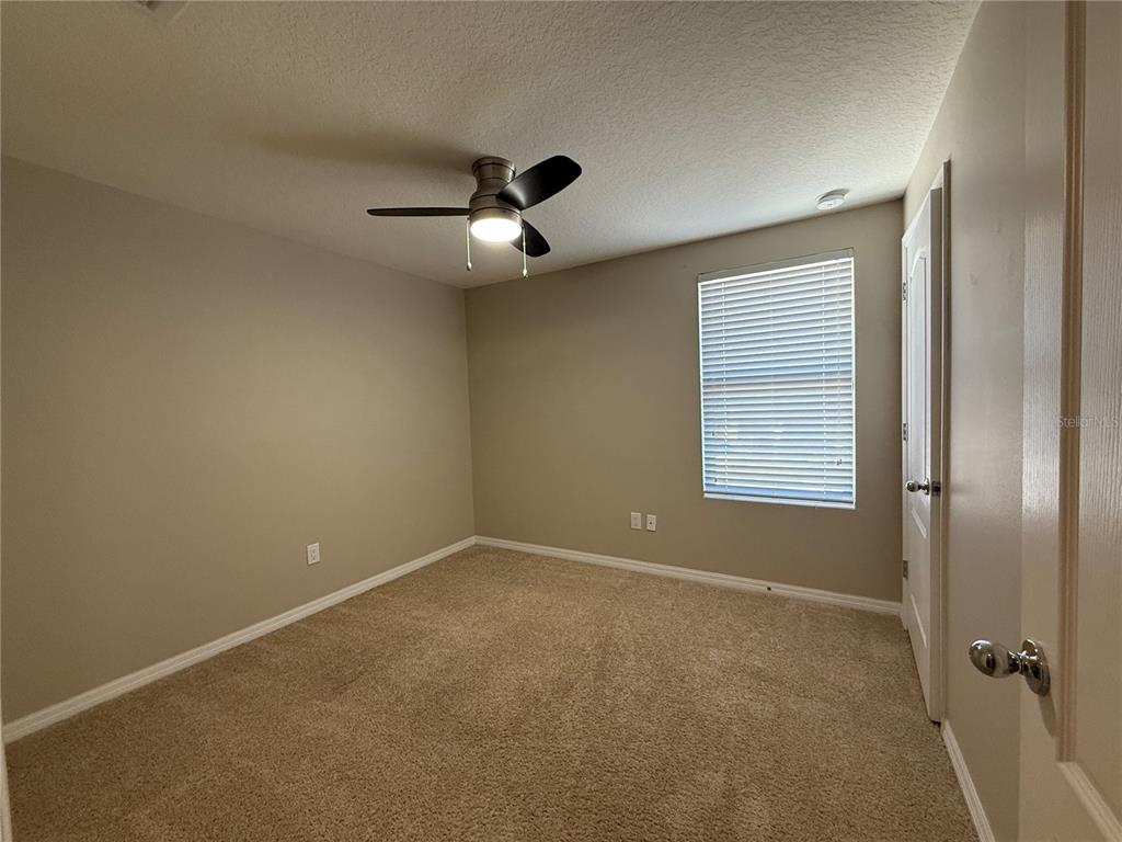 1623 Reflection Cove St. Cloud, FL 34771 - Photo 24 of 33 an empty room with a window and a fan