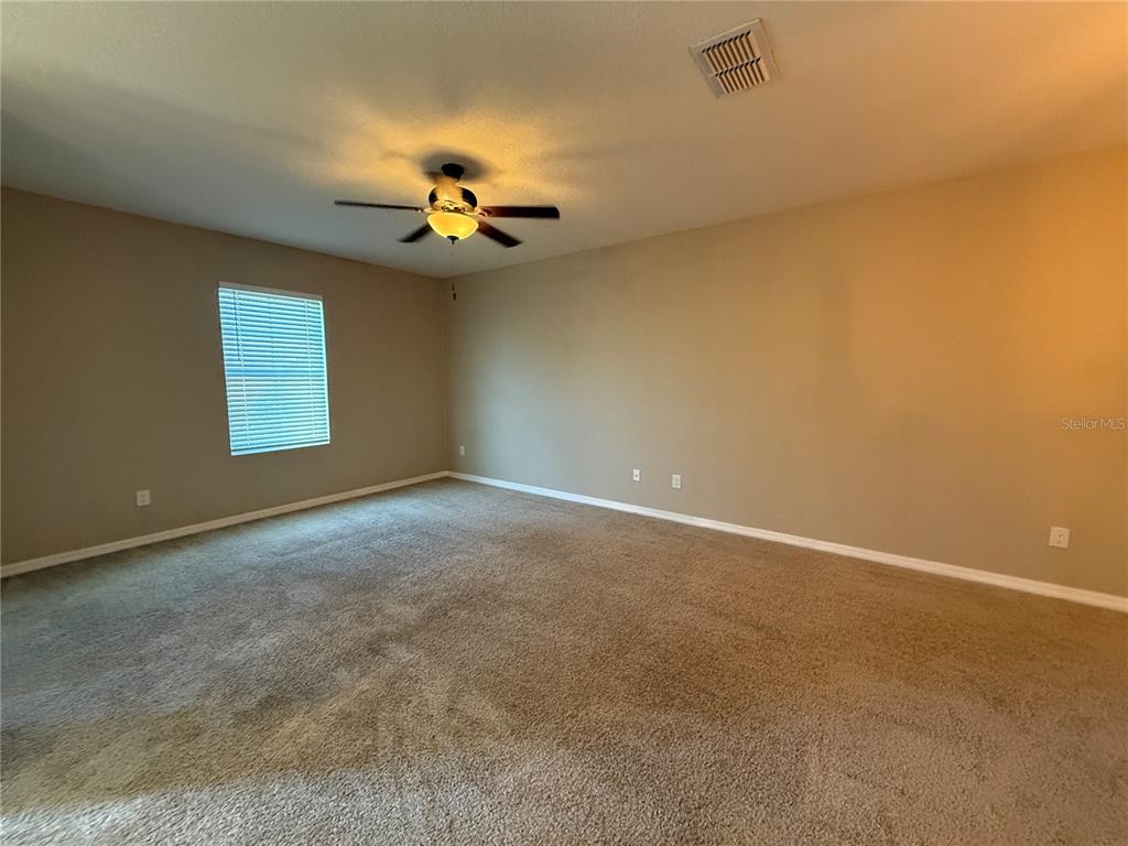 1623 Reflection Cove St. Cloud, FL 34771 - Photo 4 of 33 an empty room with windows and a ceiling fan