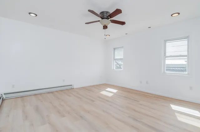 an empty room with a window and a fan