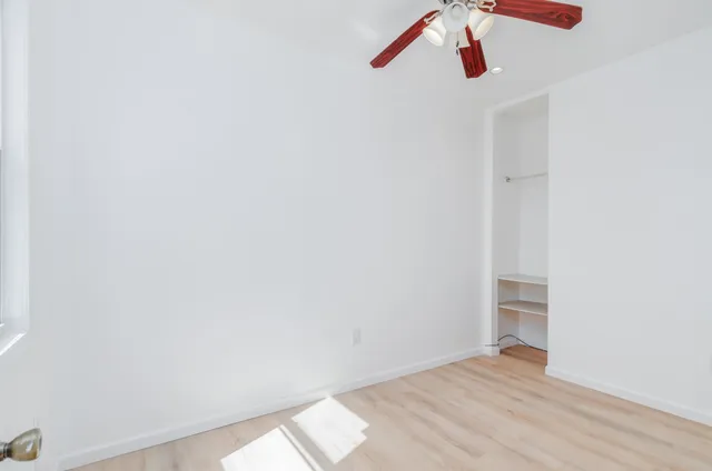 a view of a room with wooden floor and window