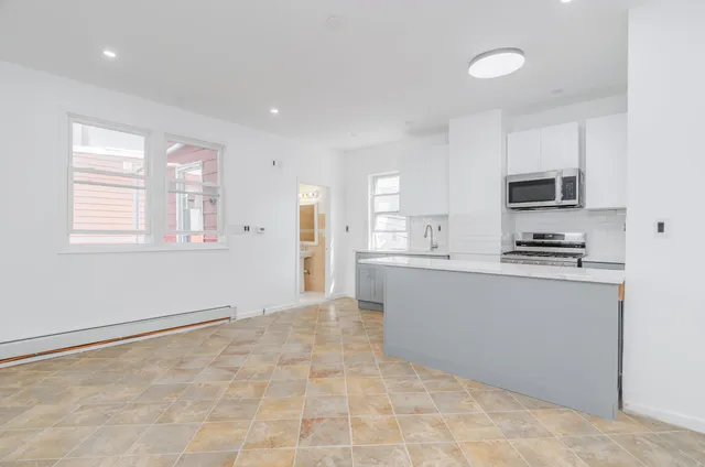 a kitchen with granite countertop a refrigerator and a stove top oven