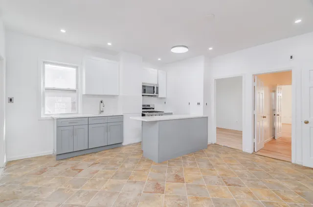 a large kitchen with a refrigerator a sink dishwasher with a stove and cabinets