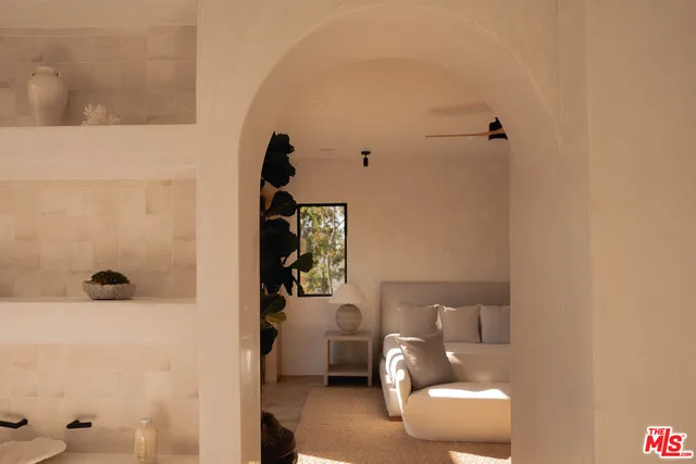 a bedroom with a bed a mirror and lamp