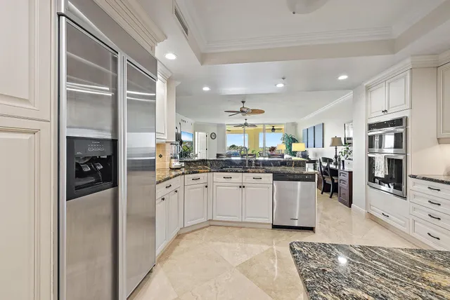 a kitchen with stainless steel appliances granite countertop a refrigerator and a sink