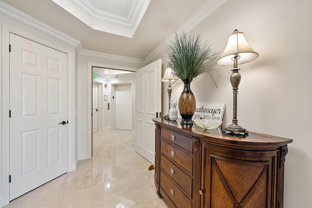 a view of hallway with a mirror and flower pot