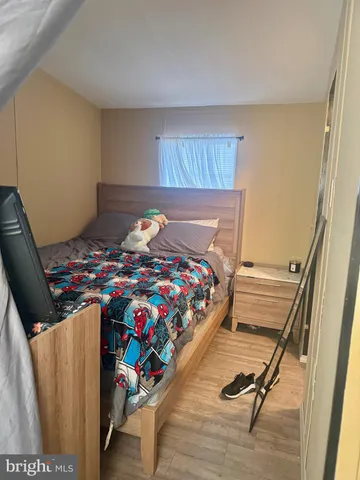 a bedroom with a bed and wooden floor