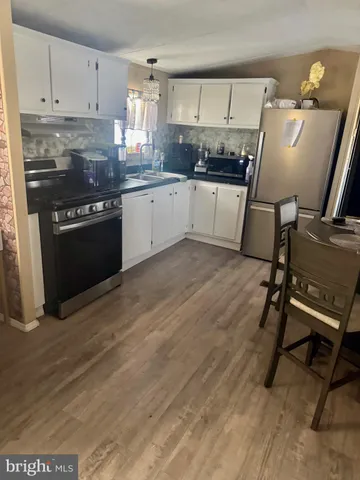 a kitchen with granite countertop a stove refrigerator and sink