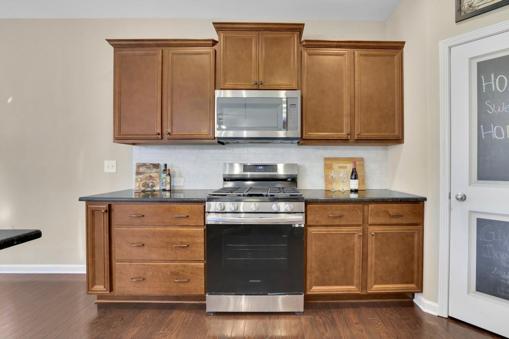 6130 Boulder Gate Way Cumming, GA 30028 - Photo 11 of 38 a kitchen with granite countertop wooden cabinets and a stove top oven
