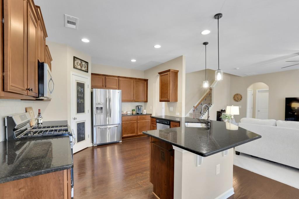 6130 Boulder Gate Way Cumming, GA 30028 - Photo 12 of 38 a kitchen with stainless steel appliances granite countertop a sink refrigerator and stove