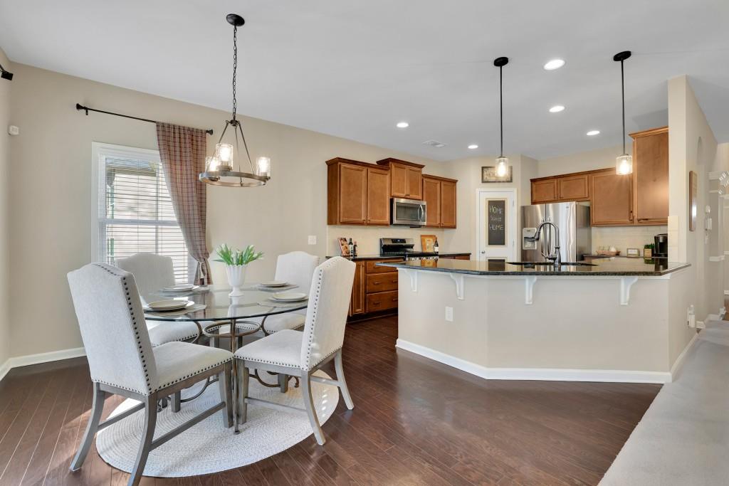 6130 Boulder Gate Way Cumming, GA 30028 - Photo 14 of 38 a view of a dining room and livingroom with furniture wooden floor a chandelier