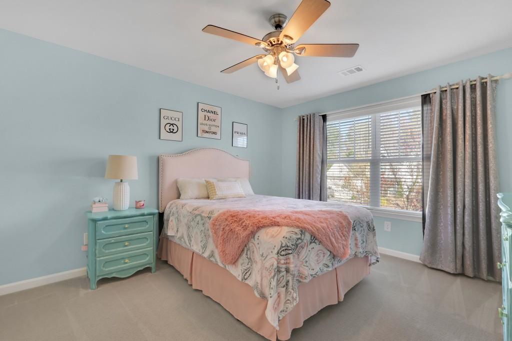 6130 Boulder Gate Way Cumming, GA 30028 - Photo 22 of 38 a bedroom with a bed a window and a chandelier