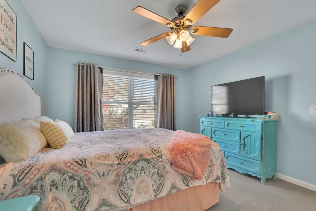 6130 Boulder Gate Way Cumming, GA 30028 - Photo 23 of 38 a bedroom with a bed and a flat screen tv