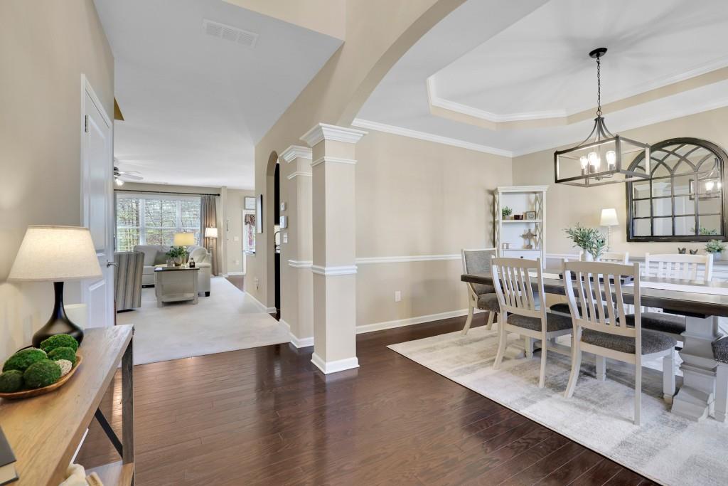 6130 Boulder Gate Way Cumming, GA 30028 - Photo 5 of 38 a dining room with furniture a chandelier and wooden floor