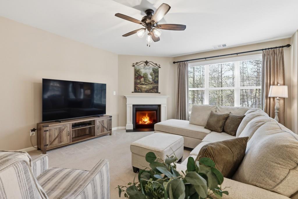 6130 Boulder Gate Way Cumming, GA 30028 - Photo 7 of 38 a living room with furniture a flat screen tv and a fireplace