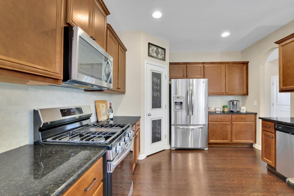 6130 Boulder Gate Way Cumming, GA 30028 - Photo 9 of 38 a kitchen with granite countertop a refrigerator stove and kitchen island