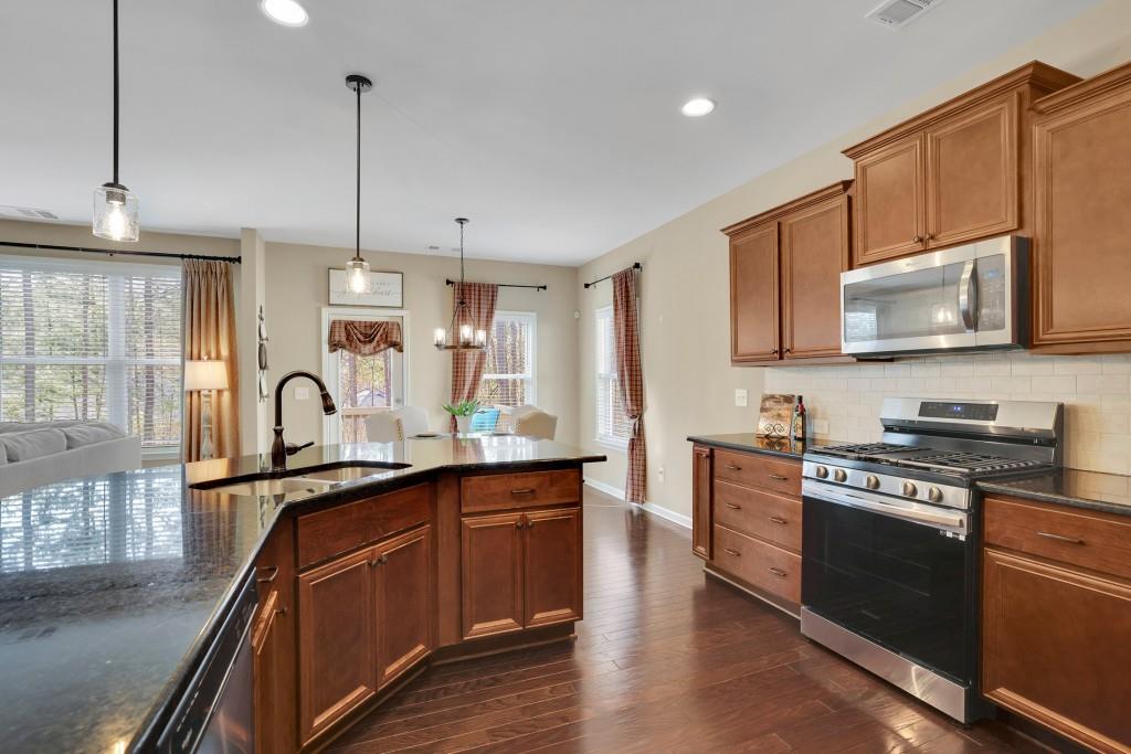 6130 Boulder Gate Way Cumming, GA 30028 - Photo 10 of 38 a kitchen with stainless steel appliances granite countertop a sink a stove and a wooden floors