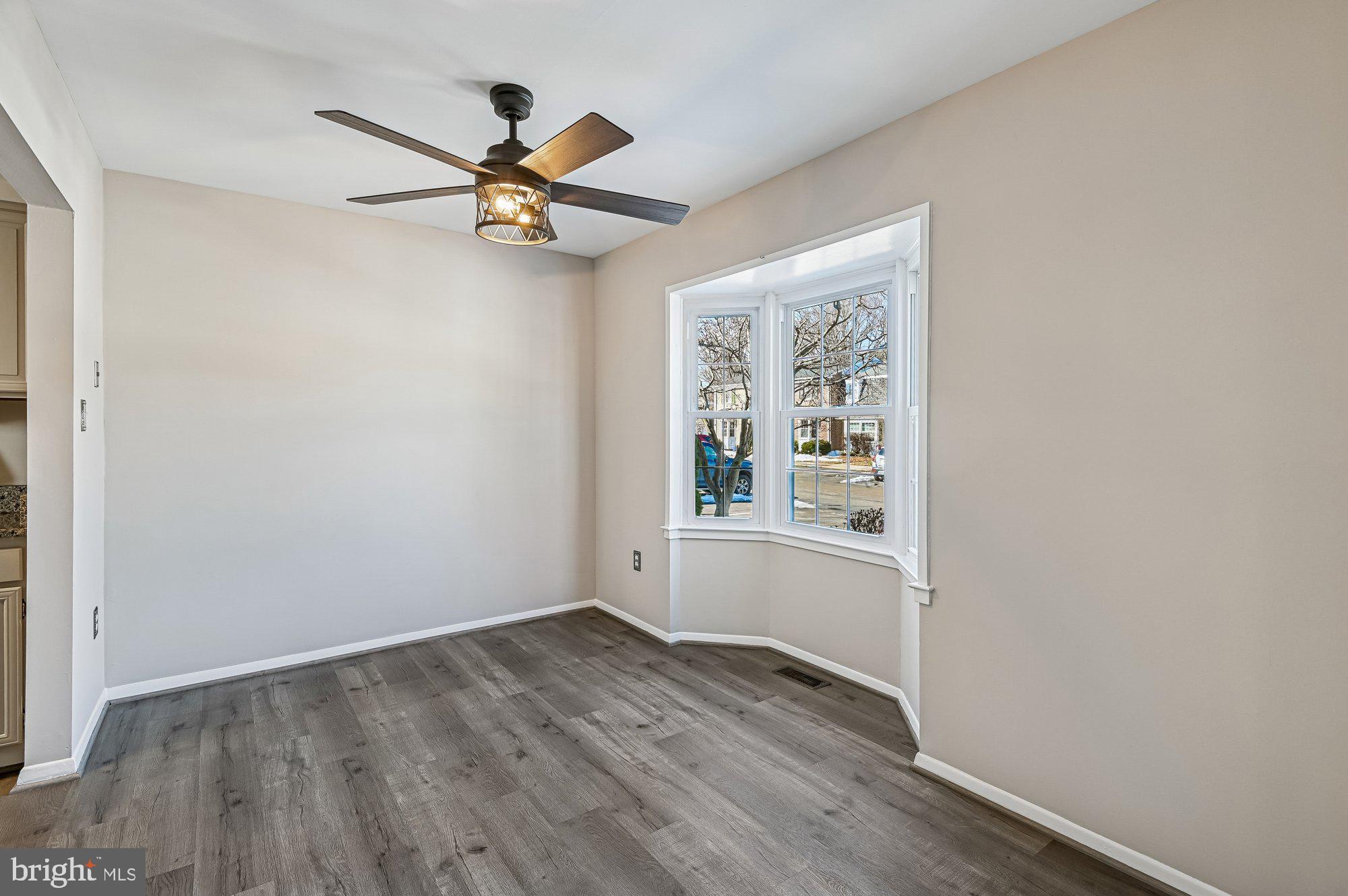 1753 Castleford Square Crofton, MD 21114 - Photo 6 of 30 an empty room with wooden floor chandelier fan and windows
