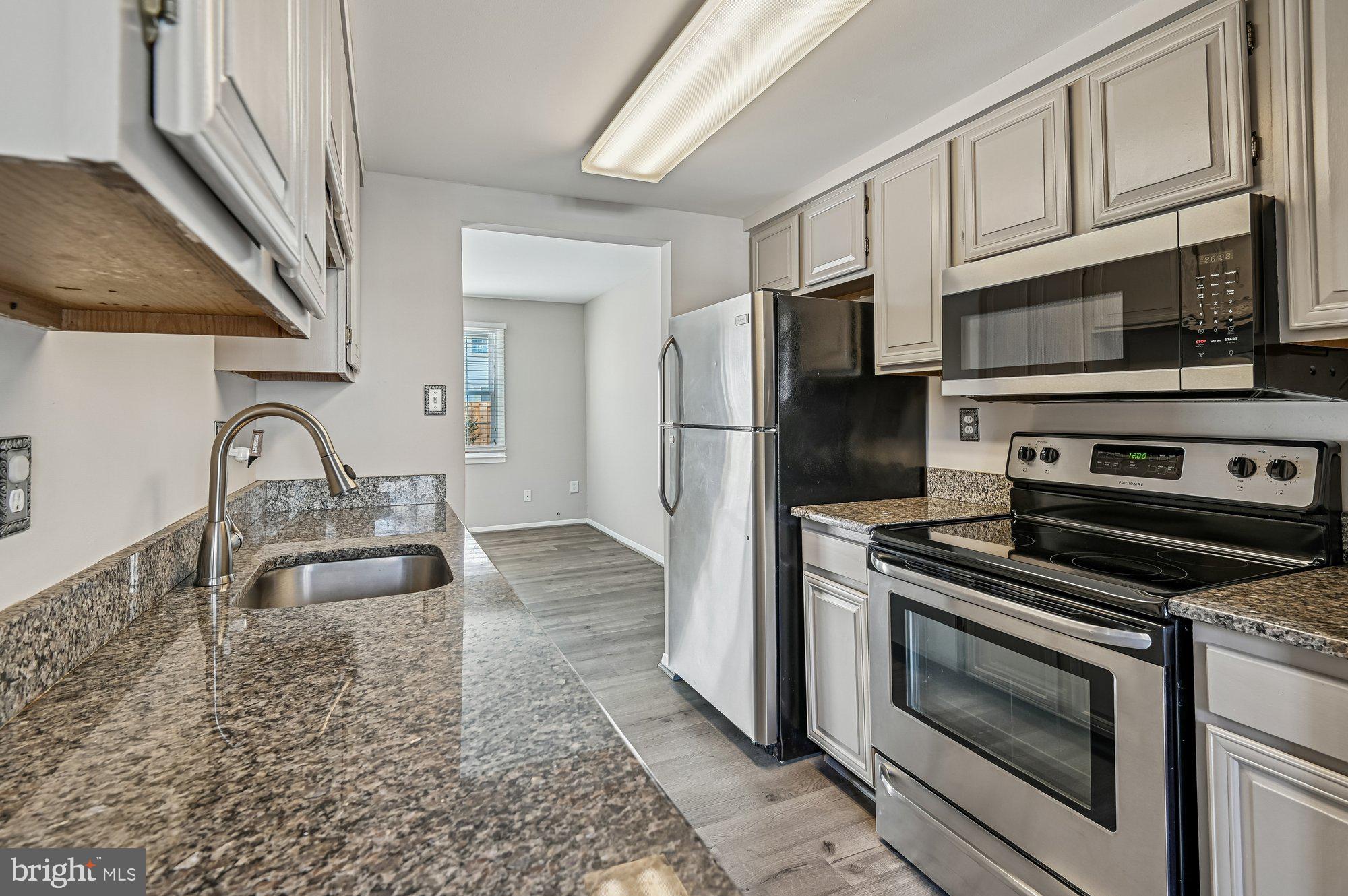 1753 Castleford Square Crofton, MD 21114 - Photo 10 of 30 a kitchen with stainless steel appliances granite countertop a sink stove and granite counter tops