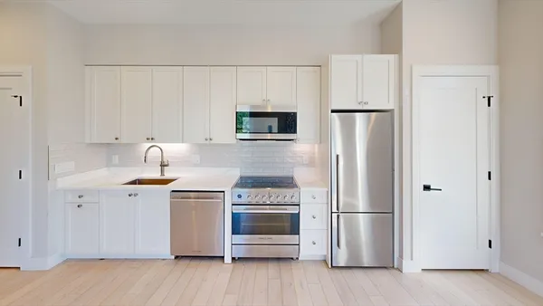 a kitchen with a refrigerator stove and white cabinets