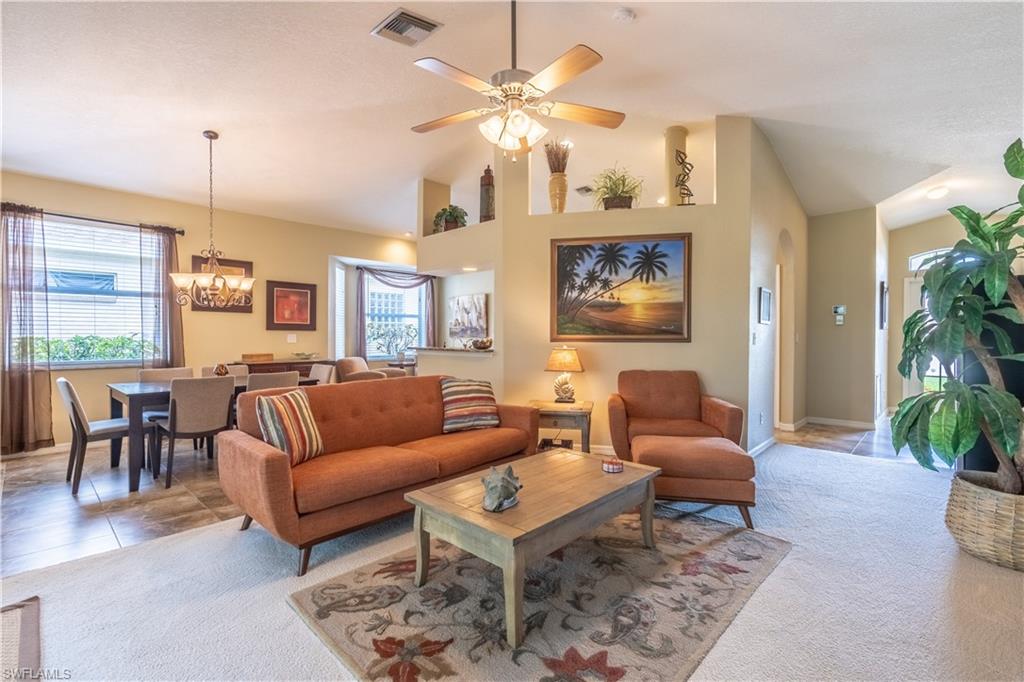 749 Crossfield Circle Naples, FL 34104 - Photo 16 of 37 a living room with furniture a chandelier and a dining table