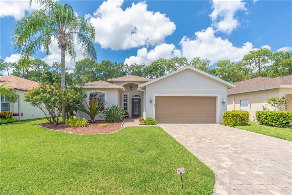 749 Crossfield Circle Naples, FL 34104 - Photo 2 of 37 a front view of a house with a yard and garage
