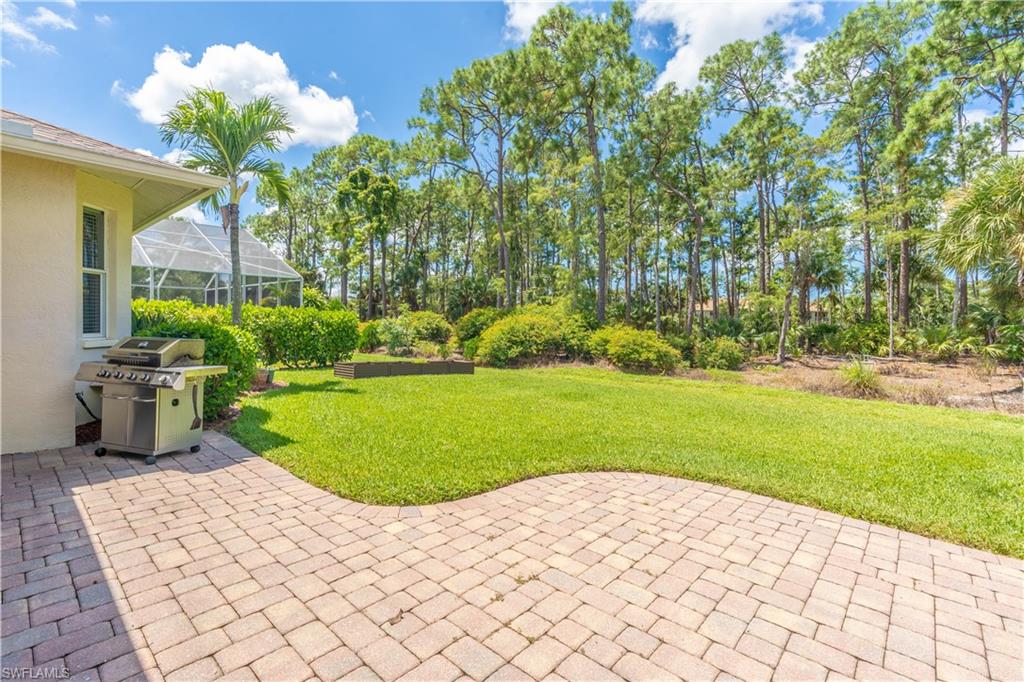 749 Crossfield Circle Naples, FL 34104 - Photo 32 of 37 a view of a swimming pool and trees in the background