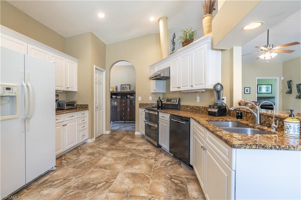 749 Crossfield Circle Naples, FL 34104 - Photo 6 of 37 a large kitchen with stainless steel appliances granite countertop a stove refrigerator sink and cabinets