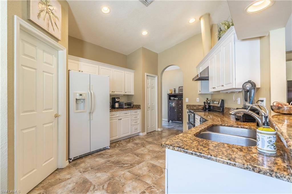 749 Crossfield Circle Naples, FL 34104 - Photo 9 of 37 a kitchen with sink refrigerator and cabinets