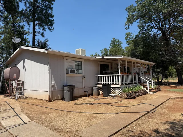 a view of swimming pool with outdoor seating and trees in the background