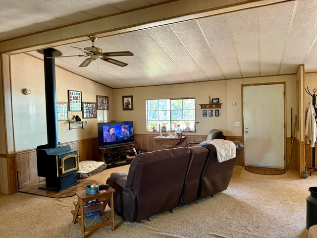 a living room with furniture a ceiling fan and a window